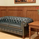 Серый диванчик в прихожей с деревянной отделкой стен